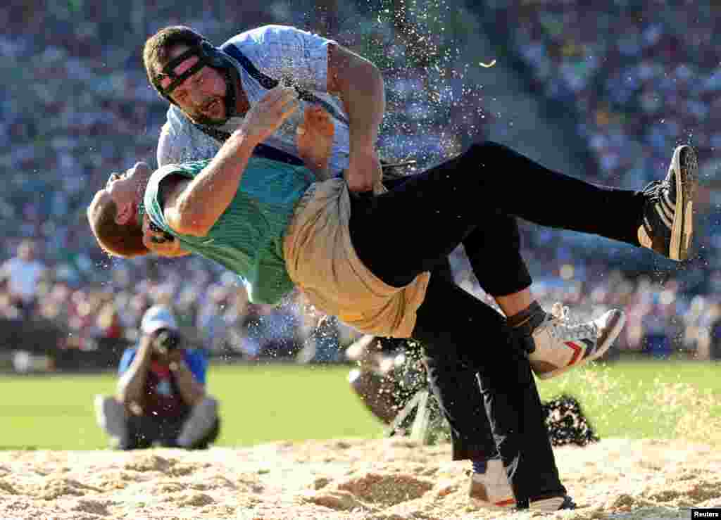 Swiss Alpine wrestlers Bruno Gisler (L) and Thomas Sempach fight during the first round of the Federal Alpine Wrestling Festival in Estavayer-le-Lac, Switzerland, Aug. 27, 2016.