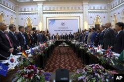 FILE - Afghan President Ashraf Ghani (C) and delegates stand for the national anthem during the Kabul Process conference, at the Presidential Palace in Kabul, Afghanistan, June 6, 2017.