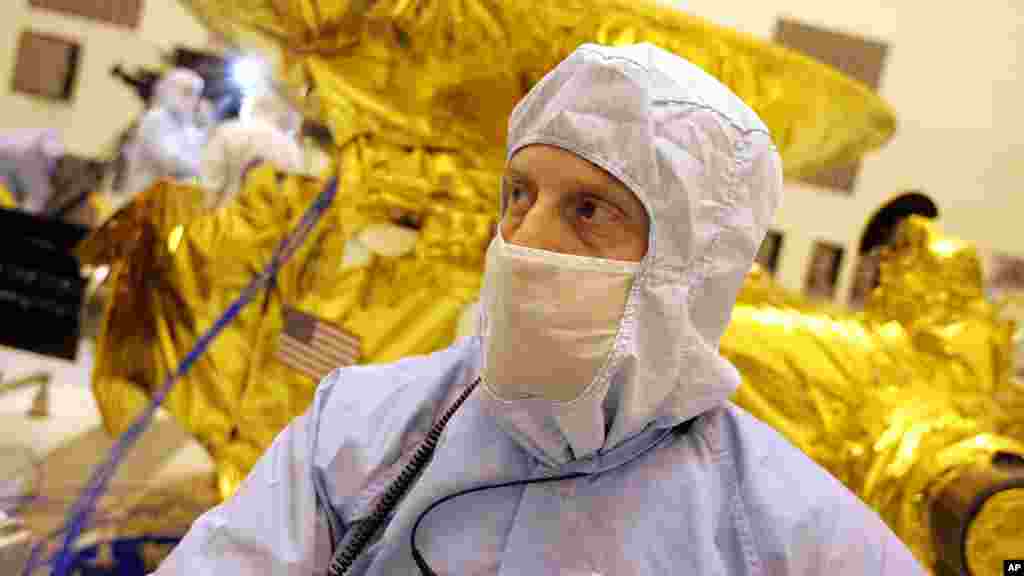 Alan Stern, principal investigator of the New Horizons mission to the planet Pluto, checks progress on assembly of the mission payload.