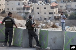 Israeli border police order a Palestinian man to lift his shirt at a checkpoint before he is allowed to exit the Arab neighborhood of Issawiyeh in Jerusalem, Oct. 20, 2015.