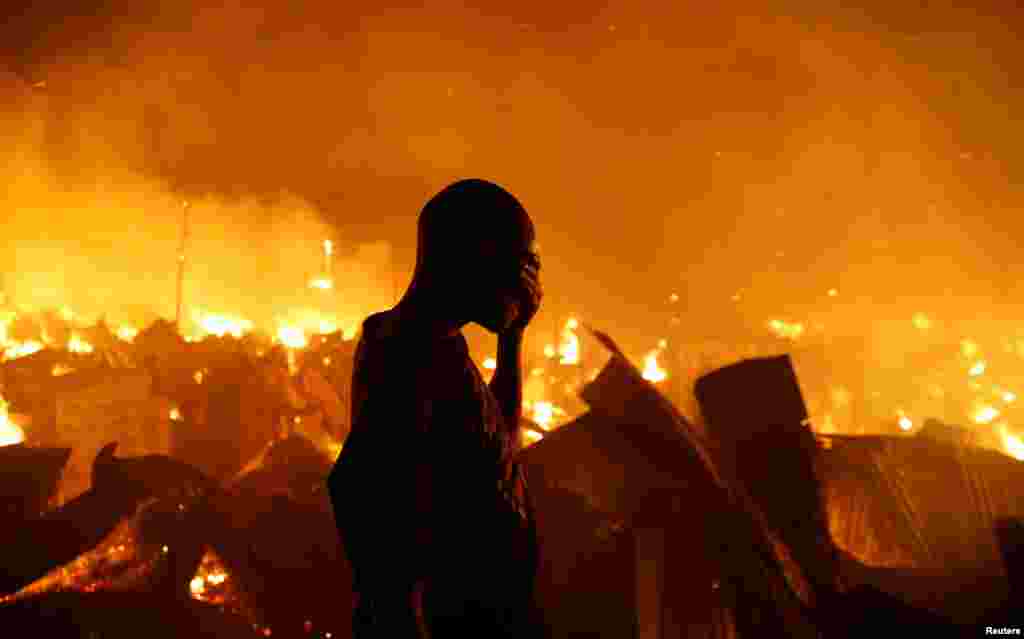 A resident reacts as he attempts to extinguish a fire that broke out at the Kijiji slums in the Southlands estate of Nairobi, Kenya, Jan. 28, 2018.