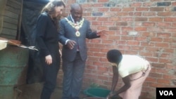 An official of the Bill and Melinda Gates Foundation (left) and Harare mayor Bernard Manyenyeni talking to a local resident. (Photo: Irwin Chifera)