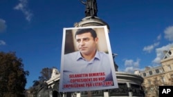 Kurdish demonstrators hold a portrait of pro-Kurdish Peoples' Democratic Party (HDP) leader Selahattin Demirtas during a rally to protest against Turkish President Recep Tayyip Erdogan, at Republique Square in Paris, France, Nov. 5, 2016. 