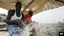 Des pêcheurs préparent leurs filets pour partir en mer au port de Guinée-Bissau, le 10 mars 2009.