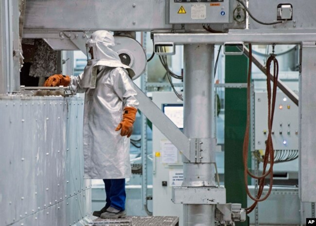 Seorang pekerja mengenakan APD, memeriksa proses produksi di pusat daur ulang dan pengecoran aluminium perusahaan AS Novelis Inc., yang berkantor pusat di Atlanta, AS, di Nachterstedt, Jerman tengah, Rabu, 1 Oktober 2014. (Foto: dok).