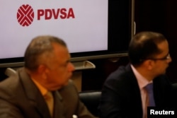 The corporate logo of the state oil company PDVSA is seen as Venezuela's Oil Minister and President of the Venezuelan state oil company PDVSA Manuel Quevedo talks to the media in Caracas, Venezuela, Aug. 7, 2018.