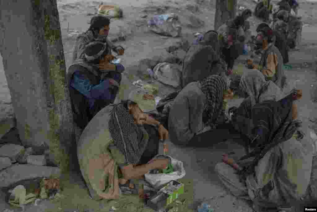 Drug addicts are seen doing drugs on the side of a road in Kabul, Afghanistan.