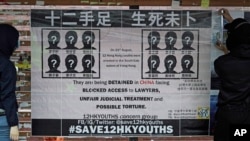 Para mahasiswa di Universitas Hong Kong memasang poster berisi tuntutan untuk membebaskan 12 aktivis Hong Kong yang ditangkap di laut oleh pihak berwenang China, 15 Januari 2021. (Foto: Kin Cheung/ AP)