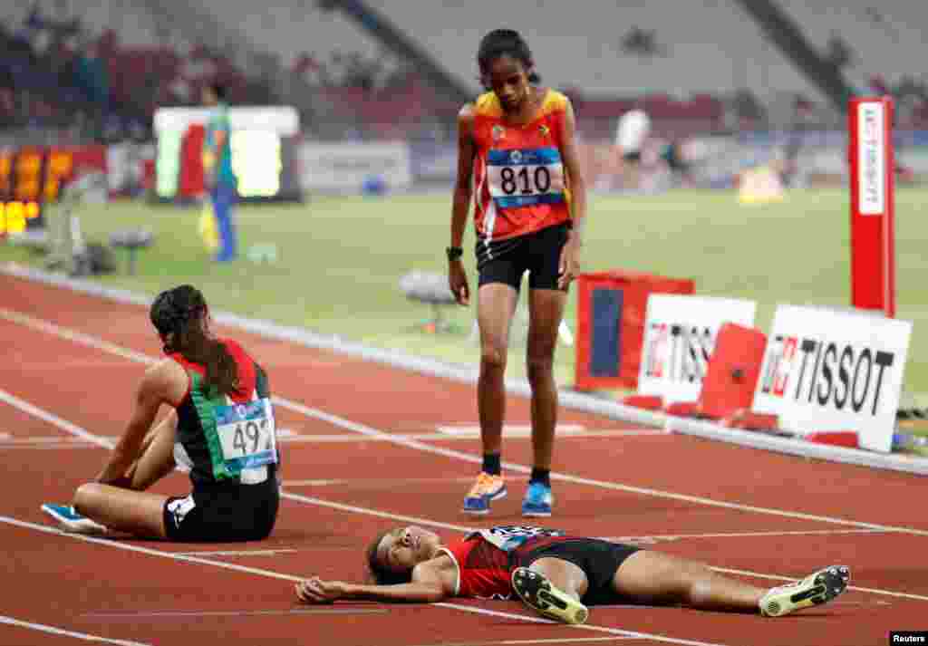 Odekta Elvina Naibaho of Indonesia collapses after women&#39;s 5000m athletics final during the 2018 Asian Games in Jakarta, Indonesia.