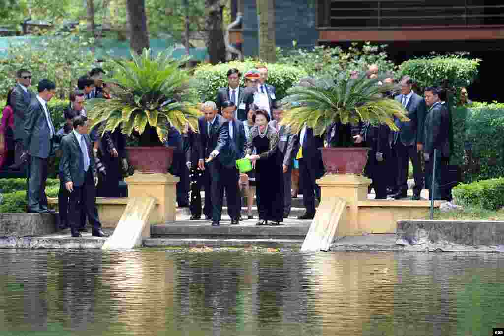 Tổng thống Mỹ Barack Obama và bà Nguyễn Thị Kim Ngân cho cá ăn tại ao cá trong phủ Chủ tịch ở Hà Nội.