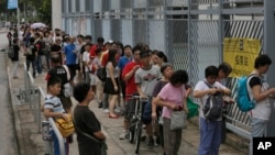 People line up at a polling center to vote in an unofficial referendum on democratic reform in Hong Kong, June 22, 2014. 
