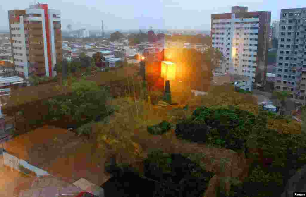 A bedside lamp is reflected in a window in a room of a Reuters photographer during a rainy day in Manaus, Brazil, June 19, 2014.