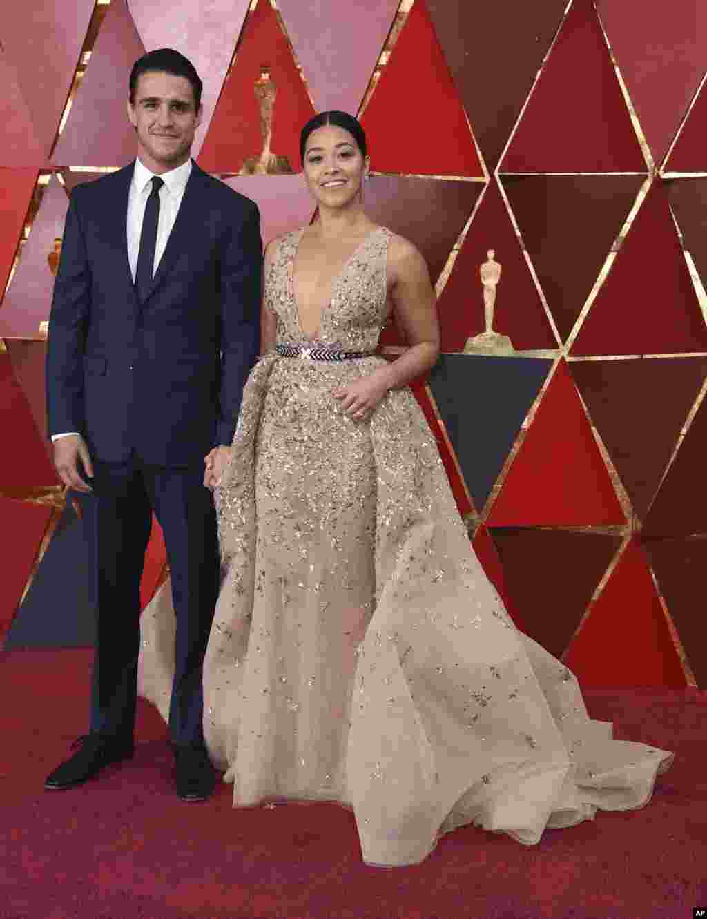 Joe LoCicero, left, and Gina Rodriguez arrive at the Oscars on March 4, 2018, at the Dolby Theatre in Los Angeles. 