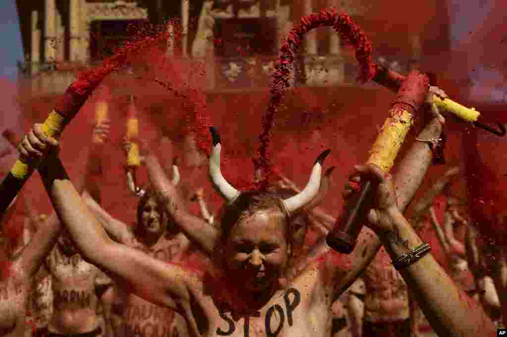 Demonstrators brake &#39;&#39;banderillas&#39;&#39; with red dust during a protest against bullfighting in front of the City Hall a day before of the San Fermin festival, in Pamplona, northern Spain.
