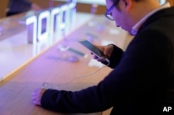 A man checks the Huawei Honor 5X, Feb. 23, 2016.