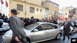 Security members and journalists surround a car with Turkey's former Chief of Staff Gen. Ilker Basbug inside as he arrives at a prosecutor's office in Istanbul, January 5, 2012.
