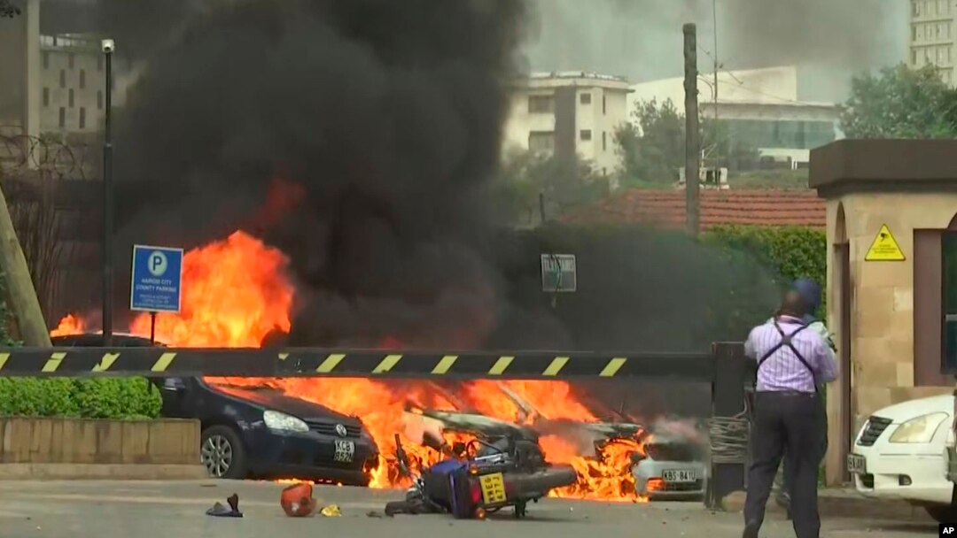 Beberapa ledakan terdengar sementara mobil-mobil terbakar di sekitar lokasi serangan di Nairobi, Selasa (15/1).