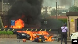 Beberapa ledakan terdengar sementara mobil-mobil terbakar di sekitar lokasi serangan di Nairobi, Selasa (15/1).