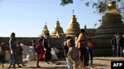 Mro ethnic people displaced from the surge of fighting between ethnic armed rebel group of the Arakan Army and government troops take refuge at a compound of a Buddhist pagoda are seen during a government-organized visit for journalists in Buthidaung town