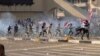 Protesters run from tear gas fired by security forces, during a demonstration by followers of Iraq's influential Shi'ite cleric Muqtada al-Sadr, in Baghdad, Iraq, Feb. 11, 2017.