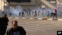 11일 바그다드 중심가에서 시위대가 경찰이 쏜 최루탄을 피해 달려가고 있다