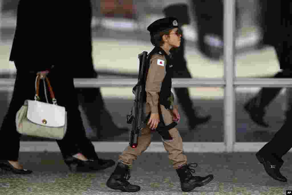 A boy dressed in a military police costume arrives to watch the Changing of the Guard at the Planalto Presidential Palace, in Brasilia, Brazil.