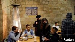 Pastor Peio Sanchez berbincang dengan para hadirin yang ikut berbuka puasa Ramadan di gereja Santa Anna di tengah pandemi COVID-19, di Barcelona, ​​Spanyol, 28 April 2021. (REUTERS / Albert Gea)