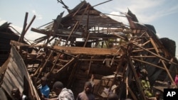 Warga memeriksa sebuah rumah yang hancur akibat serangan mortir yang memicu kemarahan masa di Goma, Republik Demokratik Kongo (24/8).