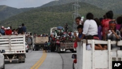 Los migrantes viajan en la parte trasera de los camiones mientras la caravana de miles de personas de Centro America que espera llegar a la frontera de EE.UU. avanza desde Juchitán, estado de Oaxaca, México, 1 de noviembre de 2018.