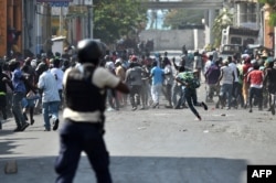 Demonstrators flee as Haitian police open fire during clashes in the center of the Haitian capital of Port-au-Prince, Feb. 13, 2019.