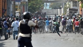 Demonstrators flee as Haitian police open fire during clashes in the center of the Haitian capital of Port-au-Prince, Feb. 13, 2019.