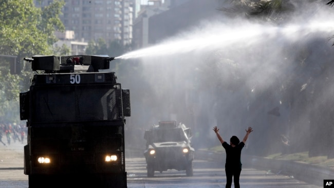 Un blindado policial dispara un cañón de agua a los manifestantes durante las protestas en Chile el 21 de octubre de 2019. AP.