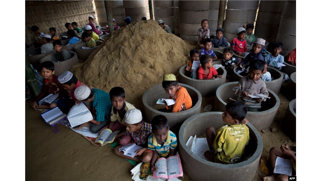 Rohingya refugee children attend recitation classes of the holy Quran in a newly opened madrasa, or religious school, amid material stocked for constructing latrines in Balukhali refugee camp, Bangladesh, Oct. 30, 2017.
