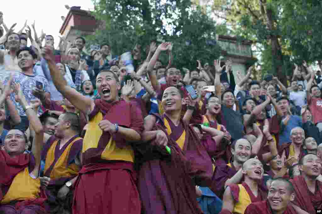 Exile Tibetan Buddhist monks cheer their team as they watch a soccer match in Dharmsala, India.