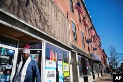 U.S. flags hang outside a downtown building whose storefronts are made up of businesses started by African immigrants who have settled in Lewiston, Maine, March 17, 2017. Maine's immigrants from Sub-Saharan Africa made $136.6 million in income in 2014, an