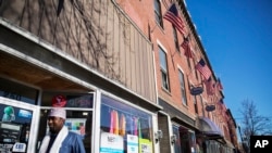 U.S. flags hang outside a downtown building whose storefronts are made up of businesses started by African immigrants who have settled in Lewiston, Maine, March 17, 2017. Maine's immigrants from Sub-Saharan Africa made $136.6 million in income in 2014, and paid $40 million in taxes, according to a report from the New American Economy. 