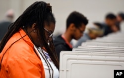 FILE - People stand cast their ballots ahead of the Nov. 6 election at Jim Miller Park, in Marietta, Ga., Oct. 27, 2018.