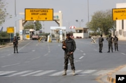 Pakistani troops stand guard on a blocked road to the Jinnah International Airport in Karachi, Feb. 28, 2019.