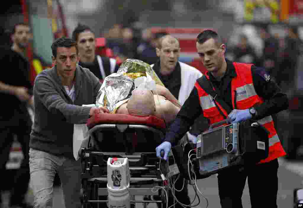 An injured person is given medical care outside the offices of Charlie Hebdo in Paris, Jan. 7, 2015.