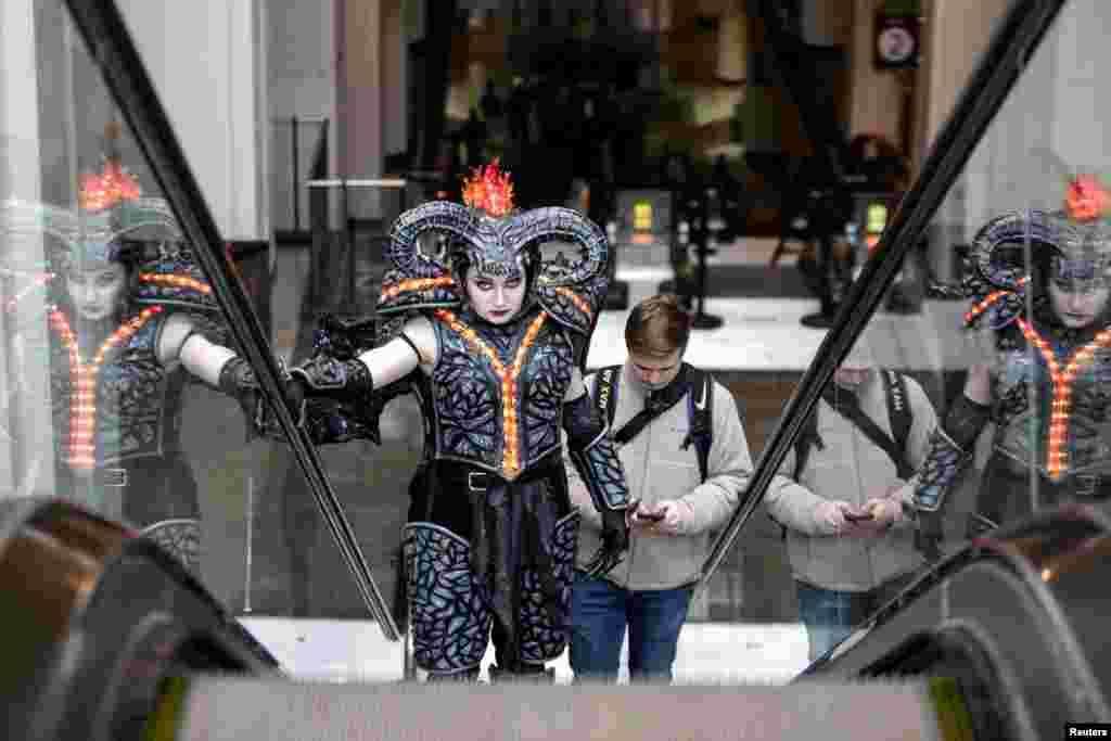 Emma Randall, dressed as Balrog from "The Lord of the Rings," and boyfriend Connor Sauby, ascend an escalator as a small group of cosplayers gather at the Washington State Convention Center in Seattle, Washington, for what would have been the 2020 Emerald City Comic Con. The event will be postponed to August due to the coronavirus (COVID-19) outbreak.