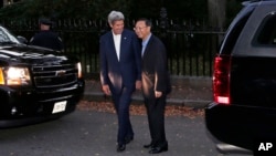 Secretary of State John Kerry, left, walks with Chinese State Councilor Yang Jiechi outside Kerry's home on Beacon Hill in Boston, Friday, Oct. 17, 2014.