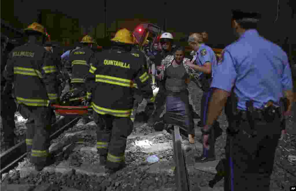 Emergency personnel help passengers at the scene of a train wreck, in Philadelphia, May 12, 2015.