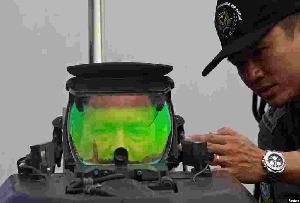 Brunei&#39;s Sultan Hassanal Bolkiah looks into the heads-up display of a Republic of Singapore Air Force Lockheed F16-D Fighting Falcon at the Singapore Airshow.