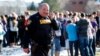 A sheriff deputy talks on his radio at Arapahoe High School where authorities say a student shot at least one other student before he apparently killed himself, in Centennial, Colorado, Dec. 13, 2013.