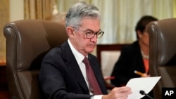 FILE - Federal Reserve Chair Jerome Powell looks over papers as the Federal Reserve Board holds a meeting at the Marriner S. Eccles Federal Reserve Board Building in Washington, Oct. 31, 2018.