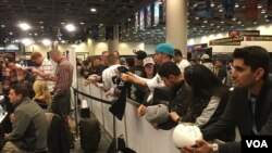 Fans watch the action on Radio Row for Super Bowl 50, at the Moscone Convention Center in San Francisco, Feb. 5, 2016. (P. Brewer/VOA)