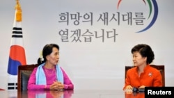 Burma's pro-democracy leader Aung San Suu Kyi (L) speaks to South Korea's President-elect Park Geun-hye during their meeting in Seoul,January 29, 2013. 