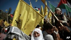 Les Palestiniens brandissent le drapeau national et celui du mouvement Fatah lors d'un rassemblement marquant le 13ème anniversaire de la mort du fondateur du Fatah et dirigeant de l'Autorité palestinienne Yasser Arafat, dans la ville de Gaza,11 novembre 2017.