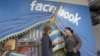 Two workers inside of Facebook headquarters in Menlo Park, Calif