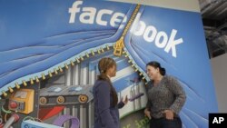 Two workers inside of Facebook headquarters in Menlo Park, Calif